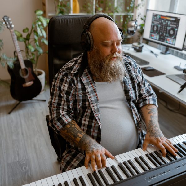 Adulte jouant du piano avec les mains détendues sur le clavier.
