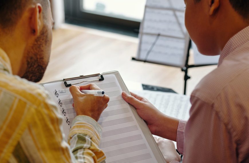 Personne examinant un contrat de cession de droits musicaux pour une publicité, avec un casque audio et un ordinateur portable.