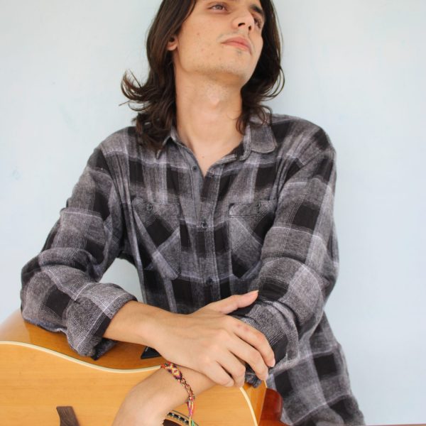 Guitariste jouant des accords dans les aigus du manche de sa guitare.