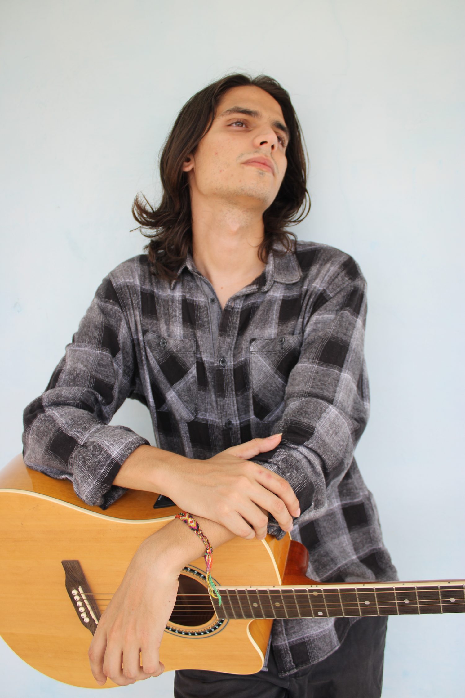 Guitariste jouant des accords dans les aigus du manche de sa guitare.