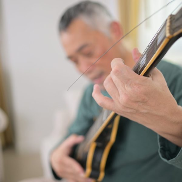Violoniste ajustant délicatement les cordes de son instrument pour éliminer un son grinçant.