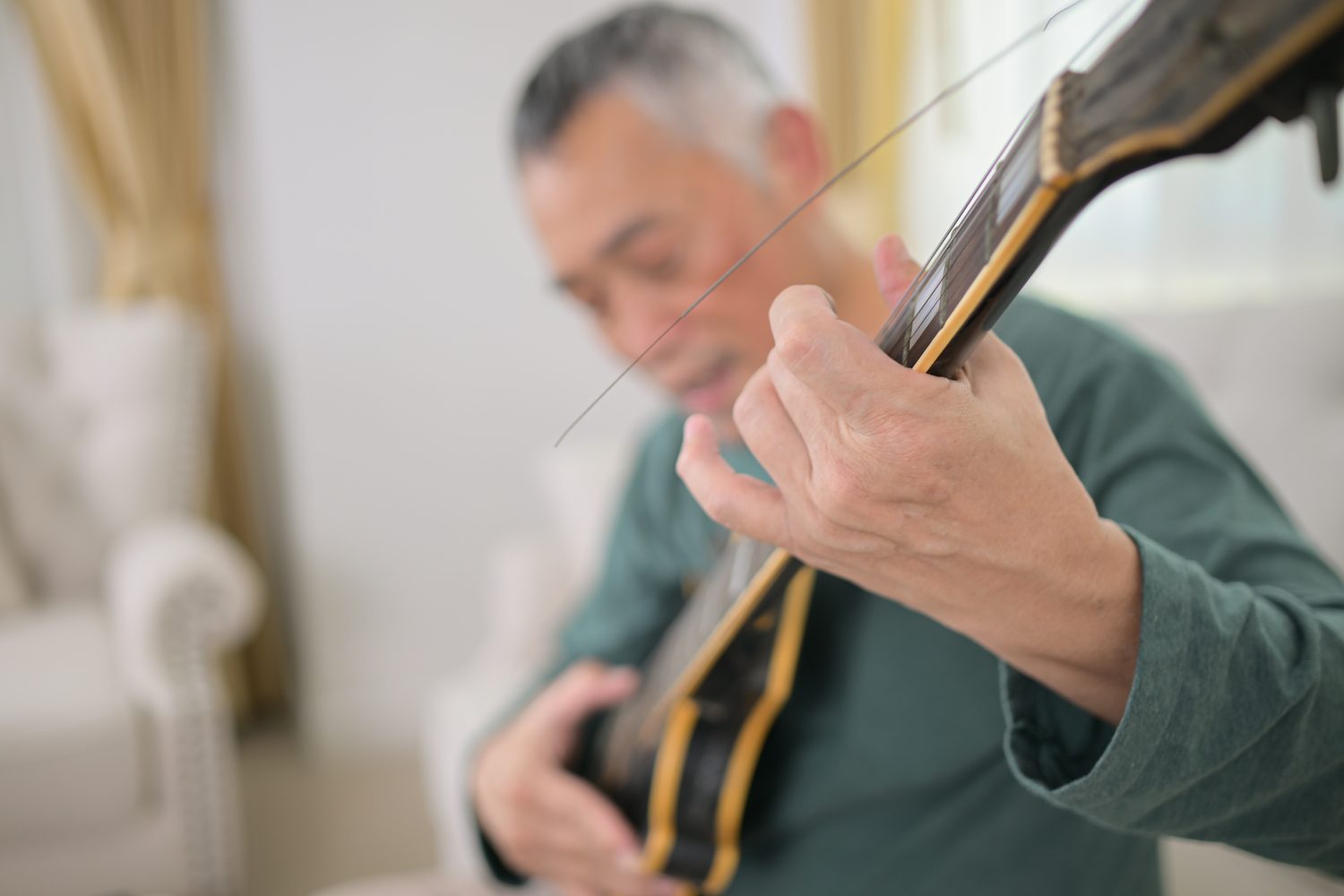 Violoniste ajustant délicatement les cordes de son instrument pour éliminer un son grinçant.