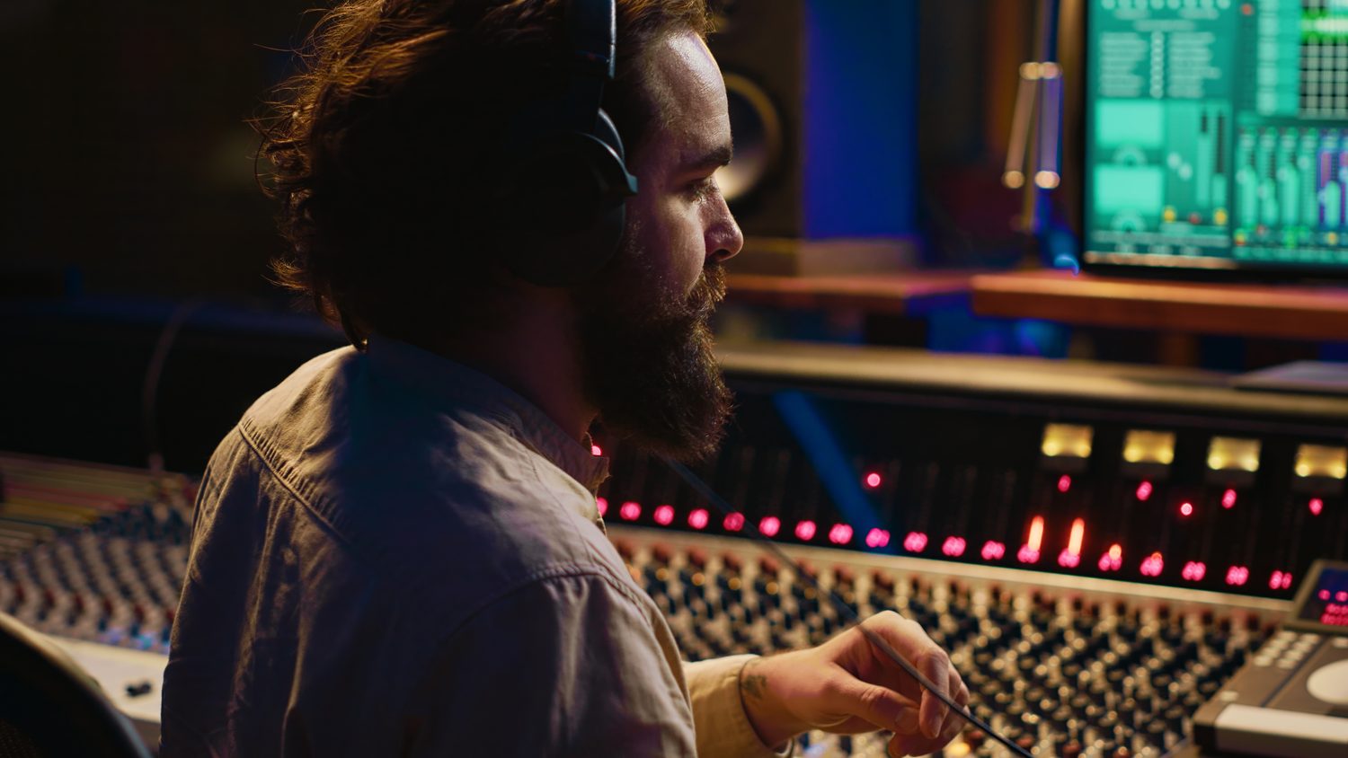 Producteur ajustant la largeur stéréo d’un synthétiseur sur une console de mixage