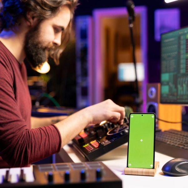 Producteur de musique testant une instru drill sur les haut-parleurs d’un téléphone.