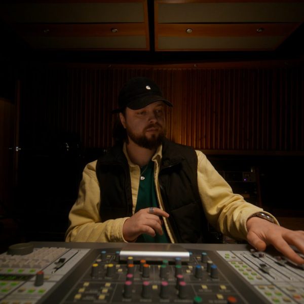 Musicien travaillant sur une production musicale dans un studio d’enregistrement.
