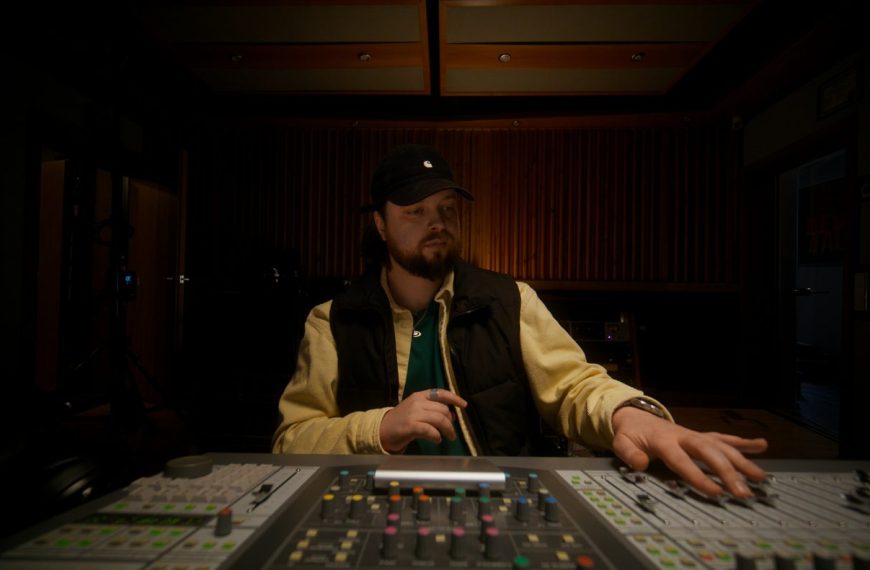 Musicien travaillant sur une production musicale dans un studio d’enregistrement.