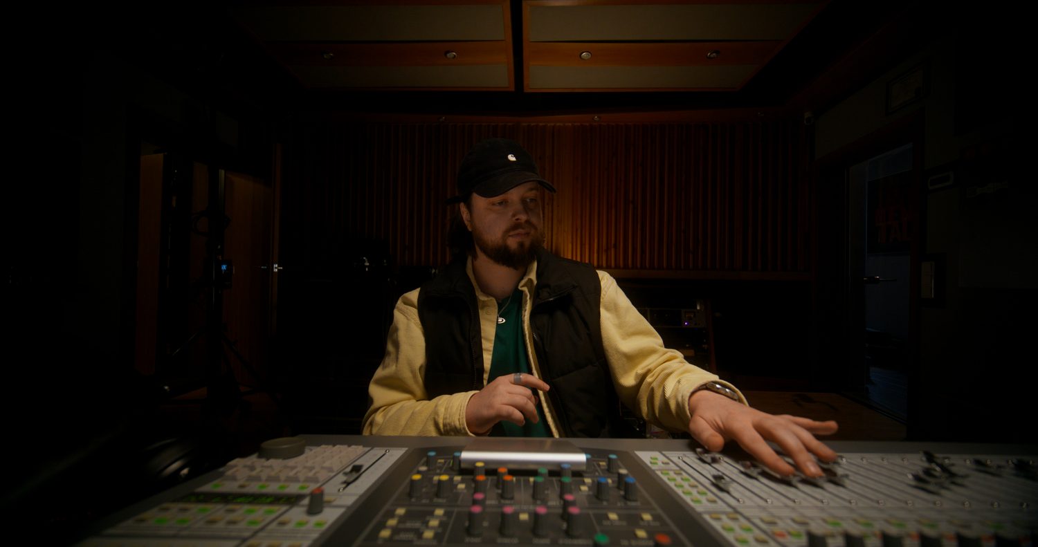 Musicien travaillant sur une production musicale dans un studio d’enregistrement.