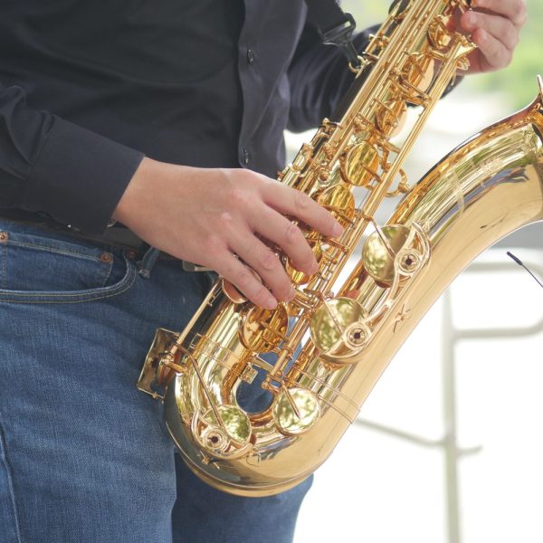 Un saxophoniste débutant examine son instrument avant de jouer.