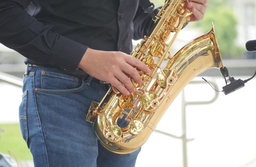 Un saxophoniste débutant examine son instrument avant de jouer.
